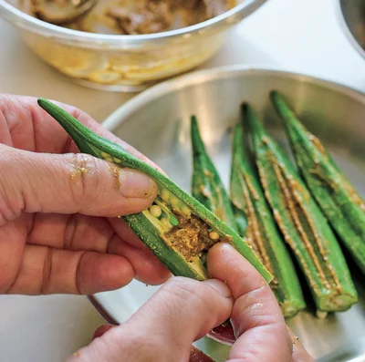 オクラの種を潰すようにしてスペースを作り、指でカレーマヨをぬる