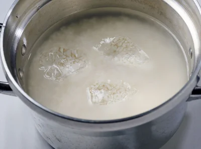 米を洗って通常どおりの量の水を加え、浸水させる。炊く前に氷をのせる。1合に対して2粒ほど（2～3cm角）が目安です
