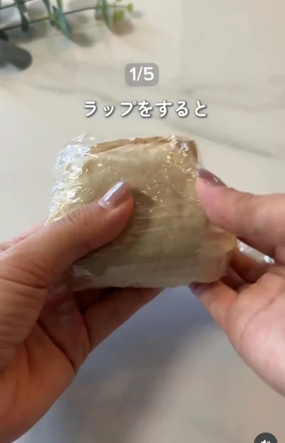 おにぎりをコーヒーフィルターに挟み、ラップで包む（⇒次へ）