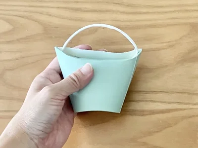 ふちを挟み込むように飲み口を折って…（▶次へ）