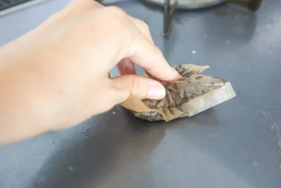 麦茶パックでコンロの油汚れをこする（▶次へ）