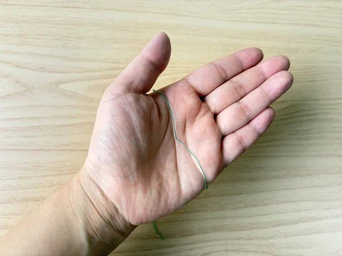 手のひらに糸をのせます(▶次へ)