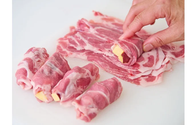 肉はパックごとひっくり返してまな板に取り出し、1枚ずつさつまいもをのせて巻くとラクチン。