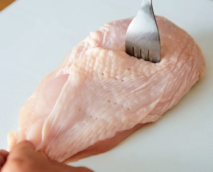 レンチンサラダチキンの作り方1 とりむね肉 大1枚(約300g)は、皮の面をフォークで10カ所ほど刺す。(作り方2に続く▶︎次へ)