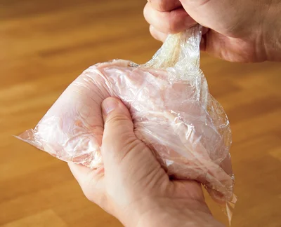 レンチンサラダチキンの作り方2　ポリ袋にとり肉とはちみつ小さじ1を入れて軽くもみ、塩小さじ1/2、酒大さじ1をふってもんで室温に30分～ 1 時間おく。※はちみつを使っているので、1歳未満の乳児には食べさせないでください。（作り方3に続く▶︎次へ）