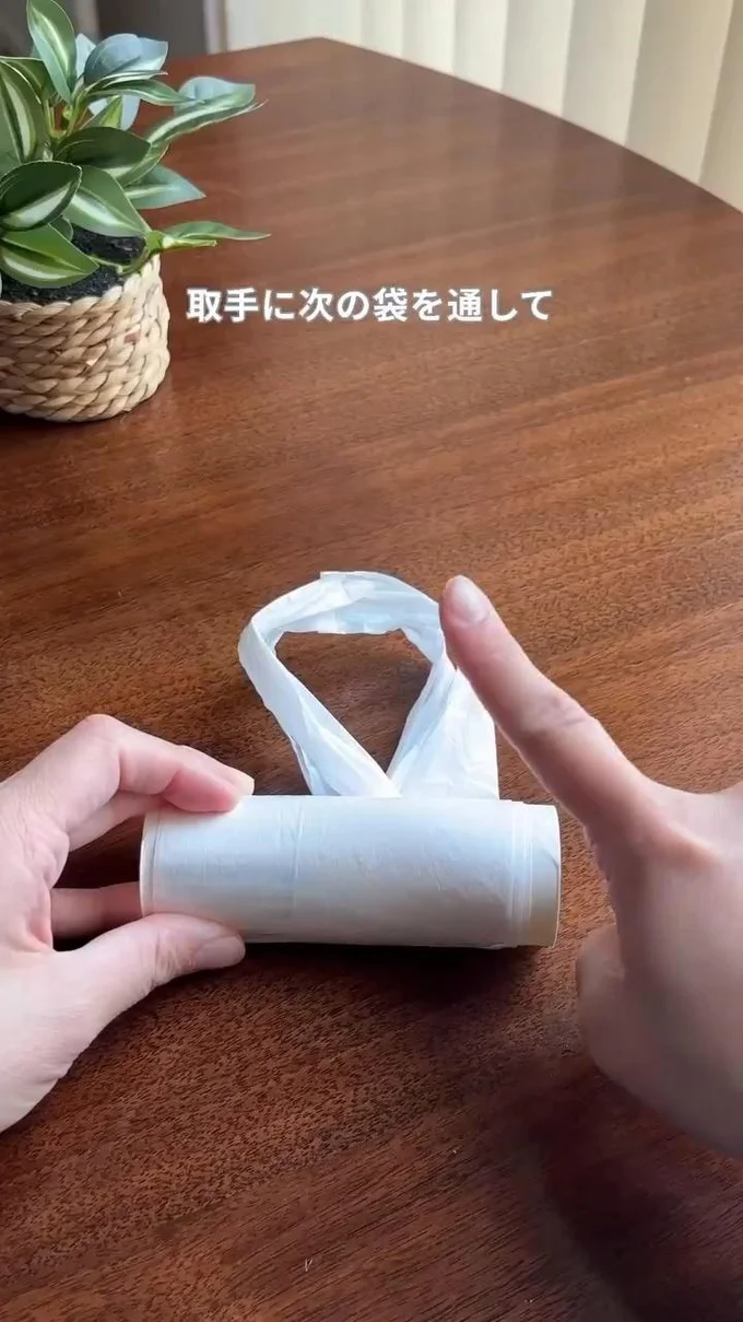 持ち手の輪っかを残す▶輪っかの中に次のレジ袋の底を通して…(⇒次へ)