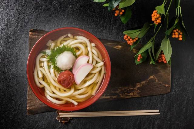 年の初めに食べる「年明けうどん」。うどんの上に紅い色の具材を添えます。