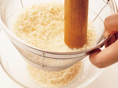 パン粉はめん棒を回すようにしてざるでこす。細かく砕いたパン粉はたねにつきやすく、しっとりとした口当たりに