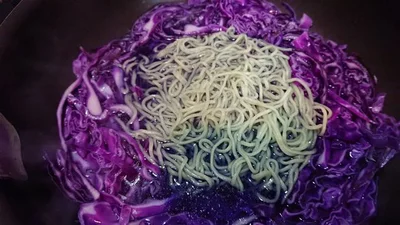 茹で汁が出た紫キャベツにそばを入れると、みるみるうちに緑に！