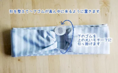 形を整えてヘアゴムが真ん中に来るように置き、ヘアゴムの下側を上の丸いモチーフに引っ掛けます