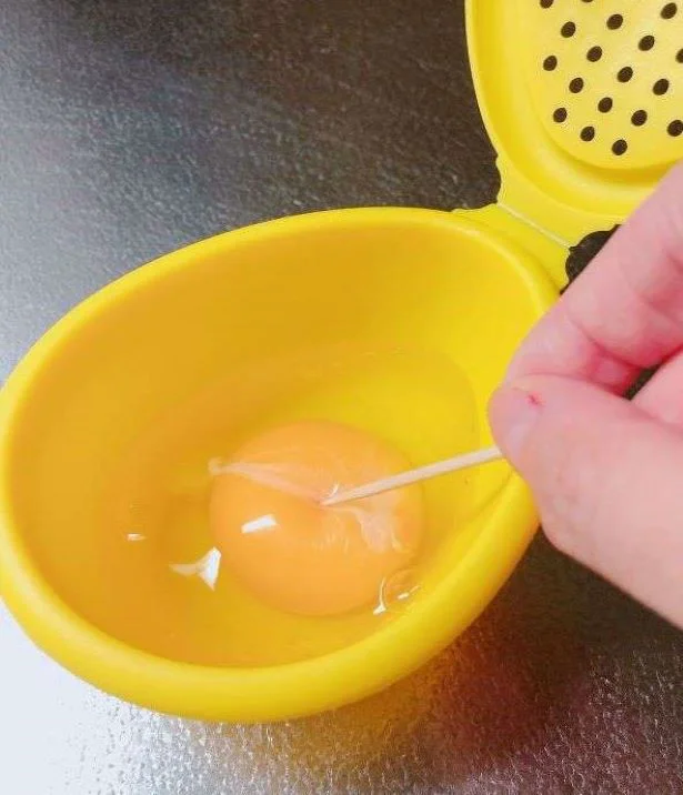 ≪作り方①≫容器の中に卵を入れて、つまようじで黄身を4～6箇所刺します