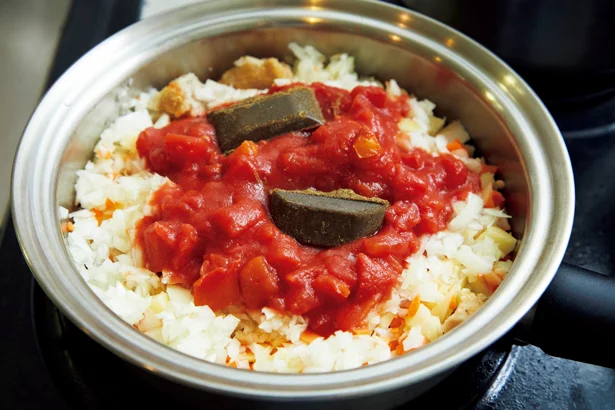 野菜のみじん切り、トマト缶、カレールウを入れて蒸し煮に