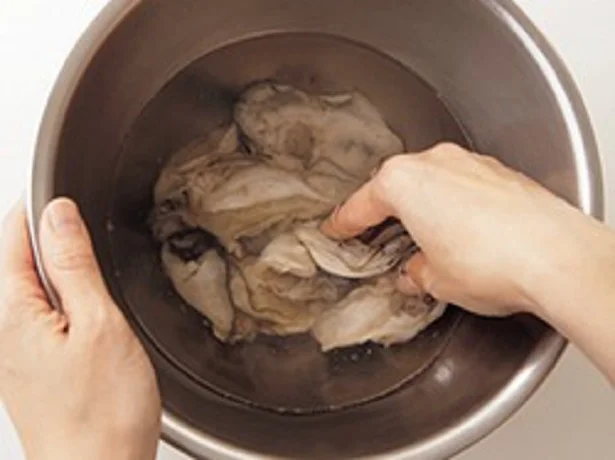ボウルに水2と1/2カップ、塩大さじ1を入れてさっと混ぜる。かきを入れて数回回し、ひだをしごいて汚れを除く。水を2回替えて洗い、ざるに上げる