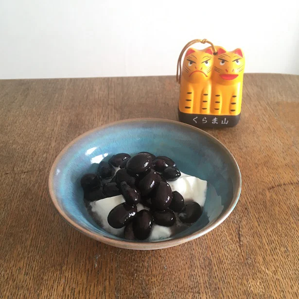 O子が毎日食べている黒豆withヨーグルト。後ろに写っているのは、鞍馬寺の福虎の土鈴です。みなさまに福が訪れますように！