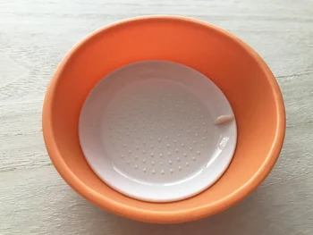 オレンジ色の本体に、白いおろし盤を入れて使う