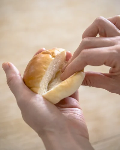 具を入れやすいように、切り目を入れたパンの断面を、指でギュッと押さえる。