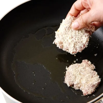 パン粉をまぶした豚肉を、片面小さじ1つずの油で焼く。少量の油でもこんがりとした焼き上がりに。