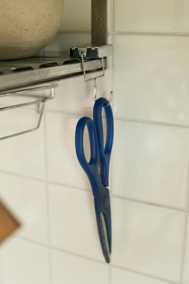 使用頻度の高いキッチンばさみは、右手で取りやすいように、つるし収納を。ワンアクションで出し戻しができる!