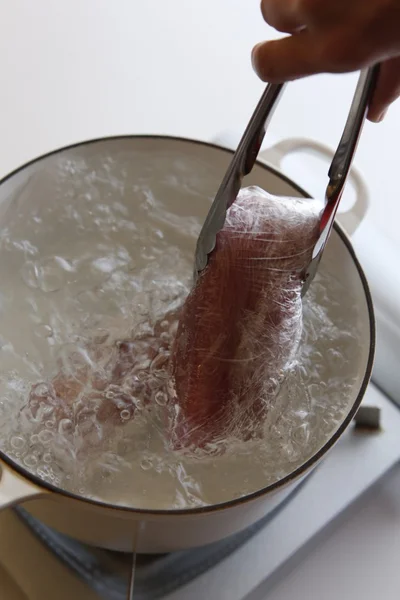 鍋に湯をわかし、豚肉をラップごと入れる。ゆで終わっても鍋から取り出さず、そのまま約2時間30分おく。