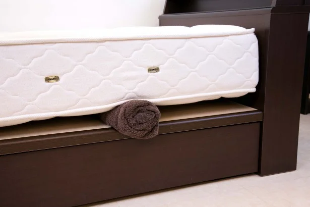 バスタオルを丸めたものや、本などをベッドの左右2か所に差し込み、空気を通すのが手軽。