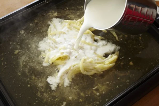 【写真を見る】まずはベースとなるホワイトグラタン作り。玉ねぎ、バター、小麦粉を炒めたら牛乳や水、スープの素などを加えてよく混ぜて