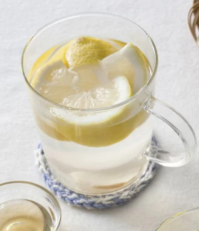 50℃しょうがレモンウォーター。カップに生姜の薄切り2枚と熱湯1カップを入れ、50～60℃にさます。国産レモン1/2個分の果汁を搾り、搾ったレモンも皮ごと加える(はちみつを加えても)