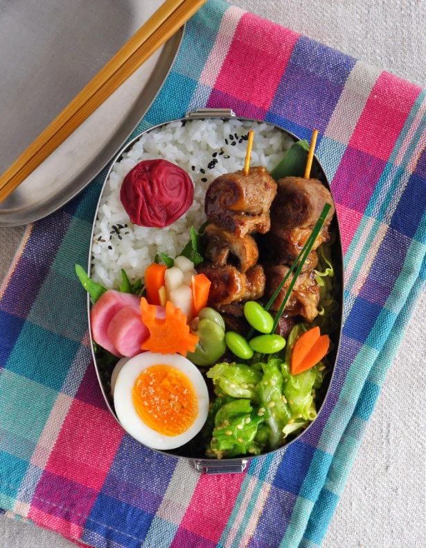 新キャベツのごま塩サラダを副菜にした、豚肉とマッシュルームの串焼き弁当。