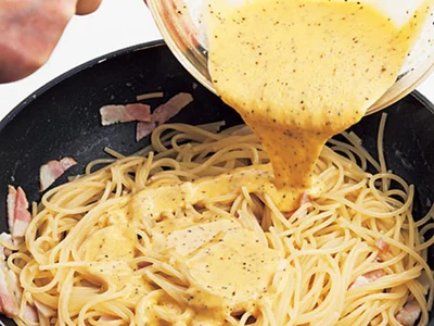 【写真を見る】フライパンでゆでるスパゲッティ。火を止めてから卵液を加え、混ぜあわせる