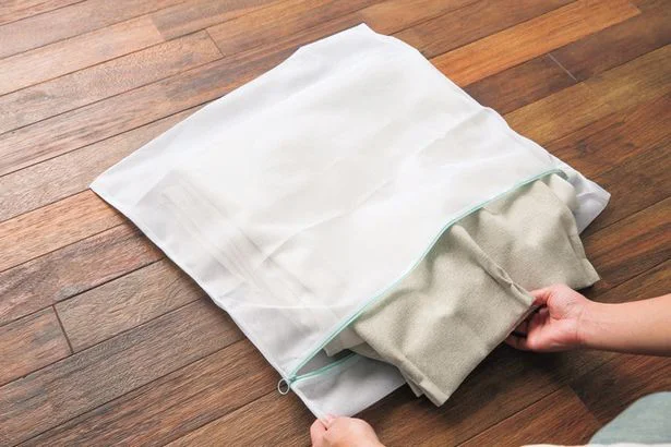 びょうぶ畳みにしたカーテンを洗濯ネットに入れる