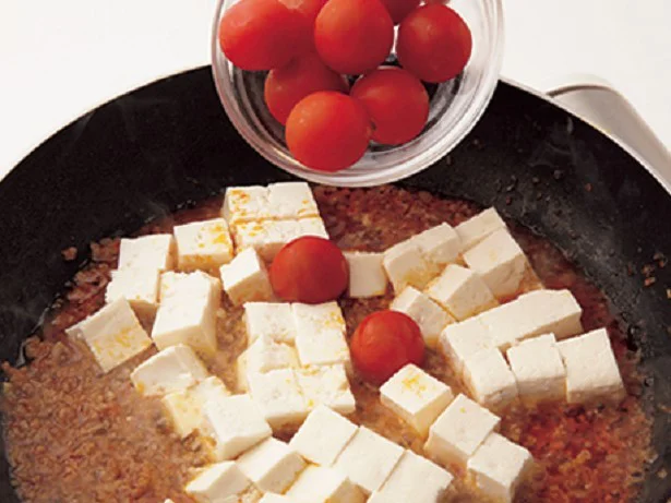 材料を煮立てうま味を引き出したところに、豆腐とトマトを加えるのがポイント 