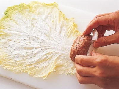 白菜の軸のほうを手前にして置き、ひき肉だねをのせ、手前から巻く。片栗粉を薄くふっておくと、たねがはがれにくくなる