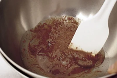 【写真を見る】ボウルにチョコレートと太白ごま油、バターを入れ、湯せんにかけてへらでなめらかに溶かし混ぜる