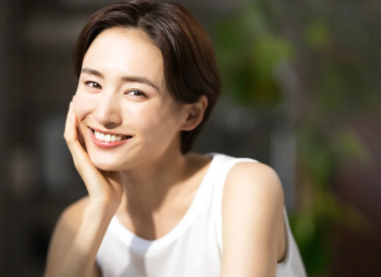 頬杖をついて微笑む女性の写真