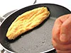 フライパンの柄をたたき、回転させる