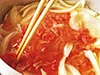 肉を入れて、煮汁の中でほぐすように混ぜる