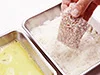 パン粉代わりの粉チーズは、手のひらで押さえて、たっぷりしっかりつけたら、軽くふって余分を落とす。