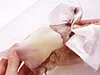 ペーパータオルで皮をつかみ、エンペラ側から足に向かって引くと、エンペラをつけたまま皮をむける。