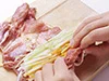 とり肉の厚みを均等に開いたら、手前に野菜をのせる。手で野菜を押さえながら、手前から向こう側に巻く。