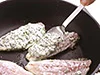 あじの片面にころもをつけてフライパンに並べたら、もう片面にはスプーンでころもをのせる。全体にまぶして焼くよりころもがよくつく。
