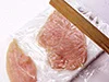 まな板の肉にラップをかけ、肉がめん棒にくっつかないようにしてたたく。肉がやわらかく、火が通りやすくなる。