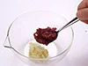 電子レンジで加熱したにんにくをつぶして、包丁でたたいた梅干しを加える。にんにくはオーブンで焼いても。
