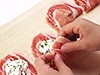 豚肉にカッテージチーズと万能ねぎなどをのせて、たたむ。チーズが流れ出ないように、カッテージチーズを使う。