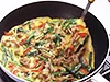 具だくさんの卵焼きは、卵液を流し入れたら手早く混ぜ、表面がほぼ乾いてきたところで、半分に折る。