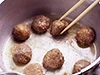 油を熱した鍋に肉だんごを入れて、周りが固まってきたら、菜箸で上下を返して火を通す。