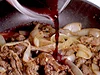 水より前にワインを加えると肉がふっくらと煮える。ワインで鍋底をこそげるようにして残さずうまみを煮汁に入れる。