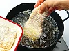 ころもをつけた肉を手で持って油の表面近くからそっと入れると安全