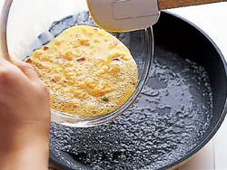 炊き上がったハムライスを溶き卵に混ぜ、１人分ずつフライパンで焼く。