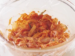 電子レンジでは塩味がしみ込みにくいので、にらを加える前にまず一度加熱して、キムチなどの味を肉にしみ込ませる。