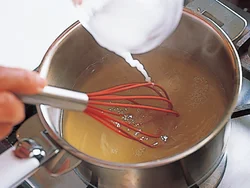 煮立ったら、一度火を止めて、片栗粉を混ぜて、とろみをつける。沈んでしまうので、泡立て器などで混ぜながら加えるのがポイント。