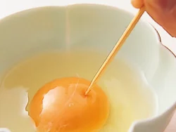 生卵をそのまま電子レンジ加熱すると破裂するので、卵黄の膜に小さく穴をあけておく。